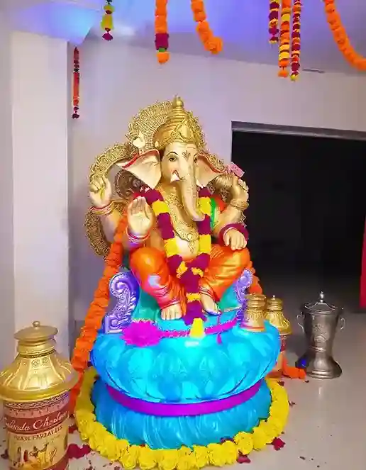 Brightly colored Ganesh Chaturthi decoration with flowers, garlands, and a traditional Ganpati idol | Bright Ganesh Chaturthi Theme with Floral Accents | Festival Decorations | Decorations Guru